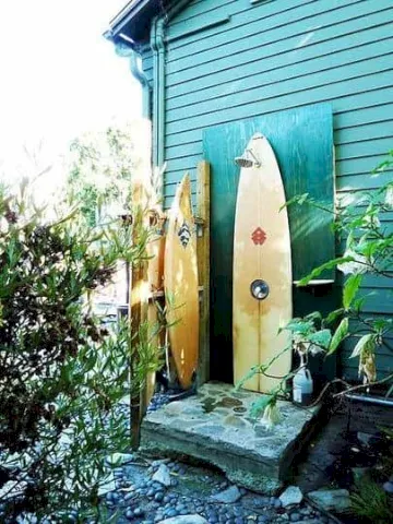 Ducha al aire libre con tabla de surf