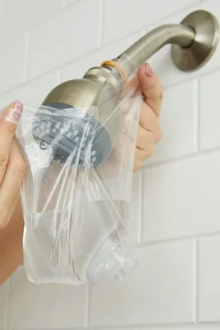 Paso 2 Remoje el cabezal de la ducha en una solución de limpieza o vinagre